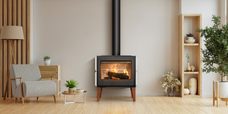 Estufa de leña Lacunza MAULE. Diseño único con patas de madera de iroko, placa de hierro fundido y revestimiento cerámico.